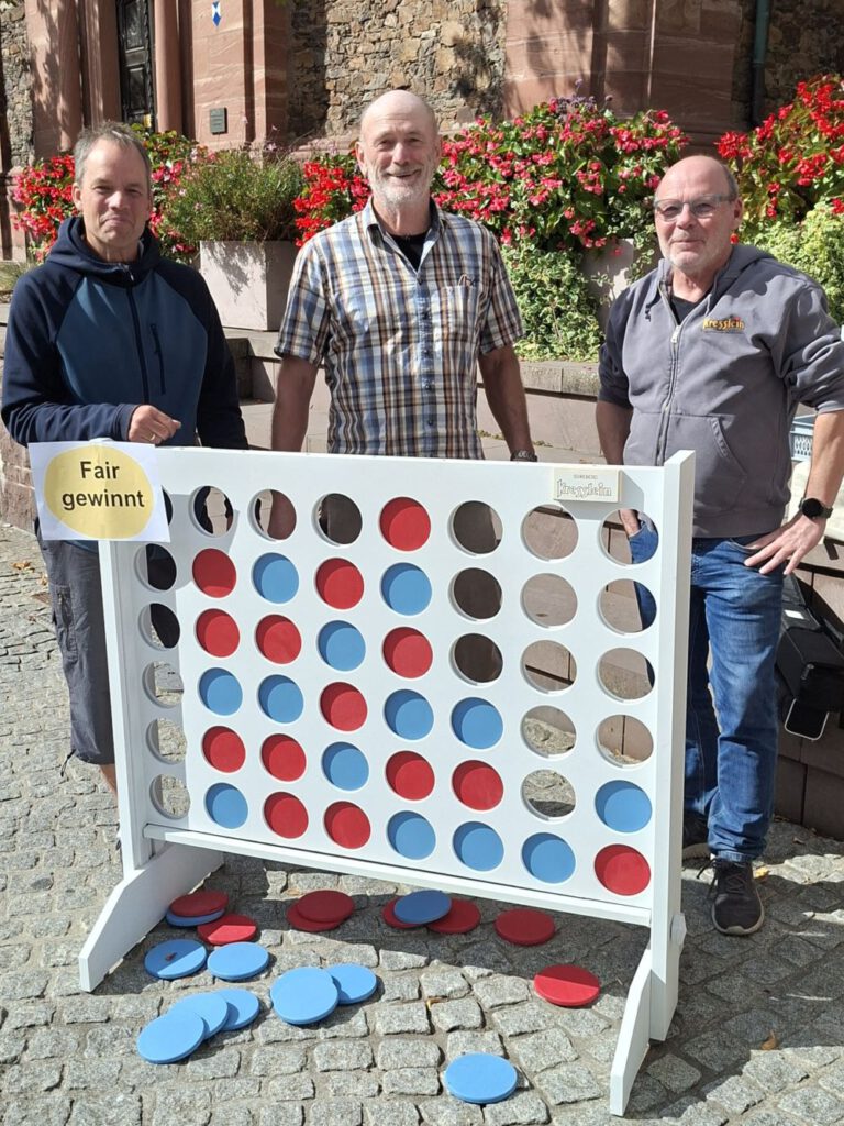 Schreinermeister Jochen Kresslein übergibt das Spiel "Fair gewinnt" an den Weltladen Alzenau
